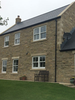 Stone house with white vertical sliding sash windows